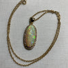 An18-carat gold, opal, and diamond pendant on a chain with a pair of earrings