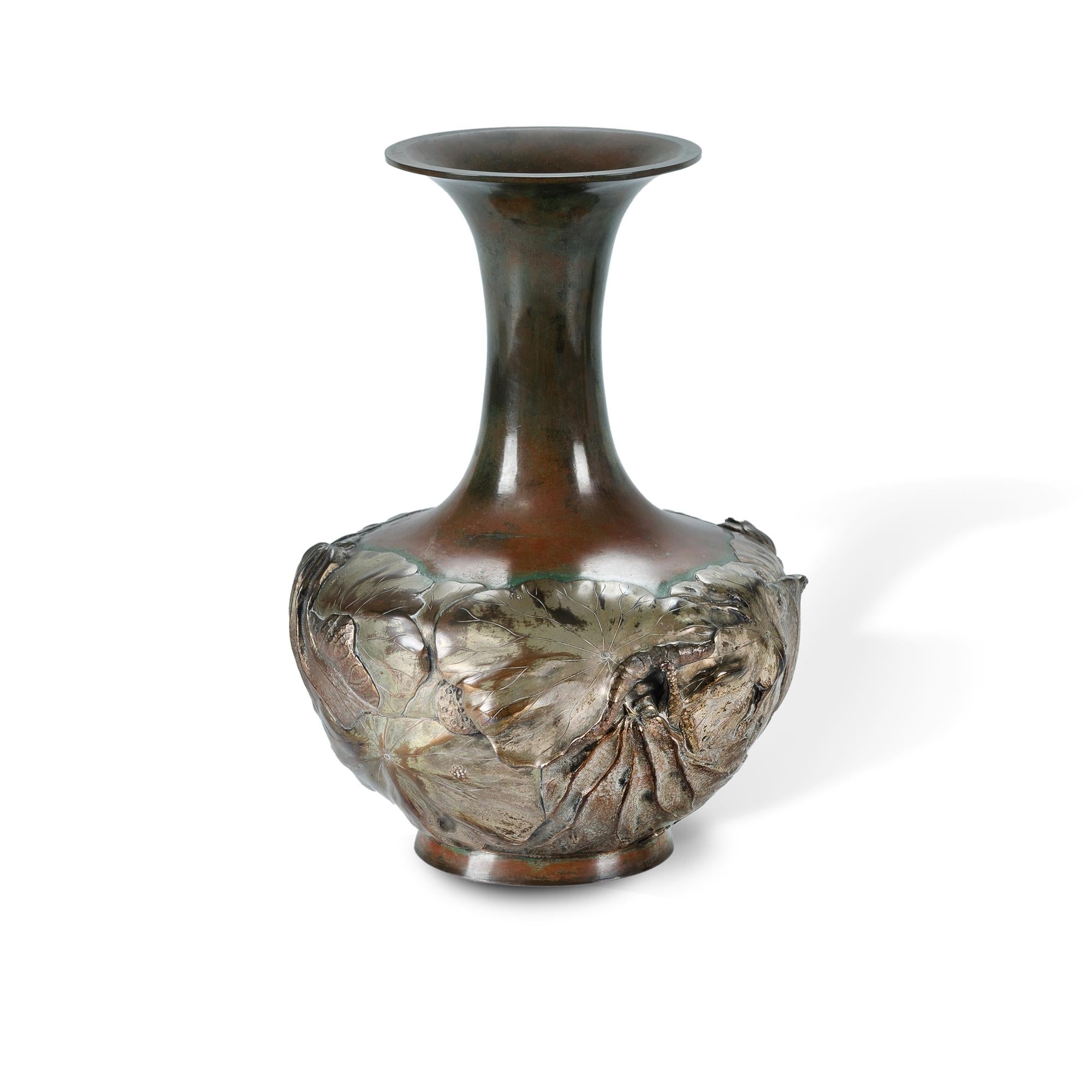 A Japanese mixed metal vase decorated with lotus plants in high relief.